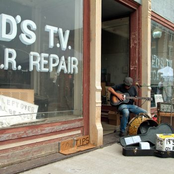 Blues musician in doorway of abandoned store, Helena, Arkansas