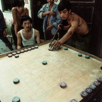Young men playing game in Chinese hutong, Guangzchou (Canton), China