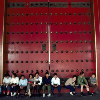 People sitting in front of large doors at the Forbidden City, Beijing, China
