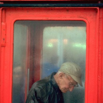 Man in British telephone booth, Blackpool, England, UK