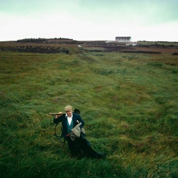 Man walking across peat field, Ireland