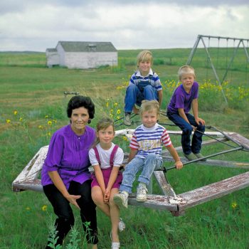 Teacher and children on overgrown playground, Arthur County, Nebraska