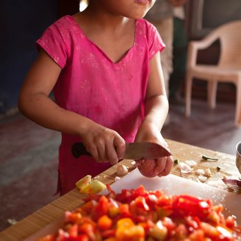 Child cutting vegetables at the Kopila Childrens Home, Surkhet, Nepal. Opening Our Eyes Movie.