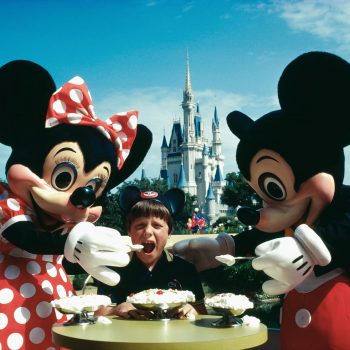 Mickey and Minnie Mouse feeding child ice cream., Walt Disney World, Orlando, Florida